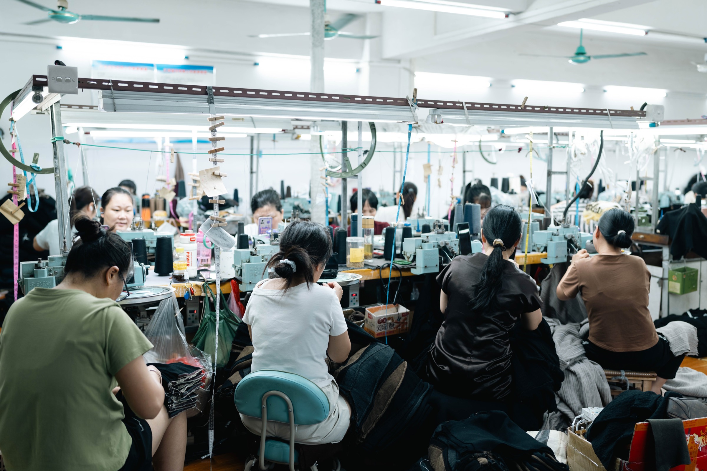 Operators working at rows of linking and sewing machines